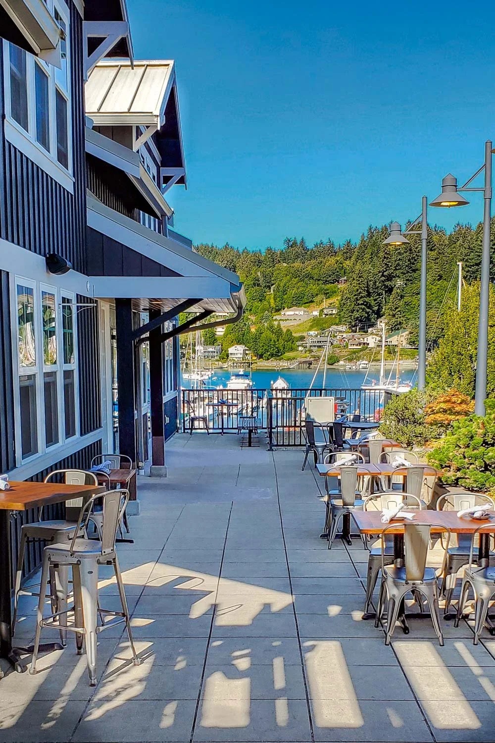 Tables on the Brix 25° waterfront deck overlooking the Gig Harbor marina on a clear day