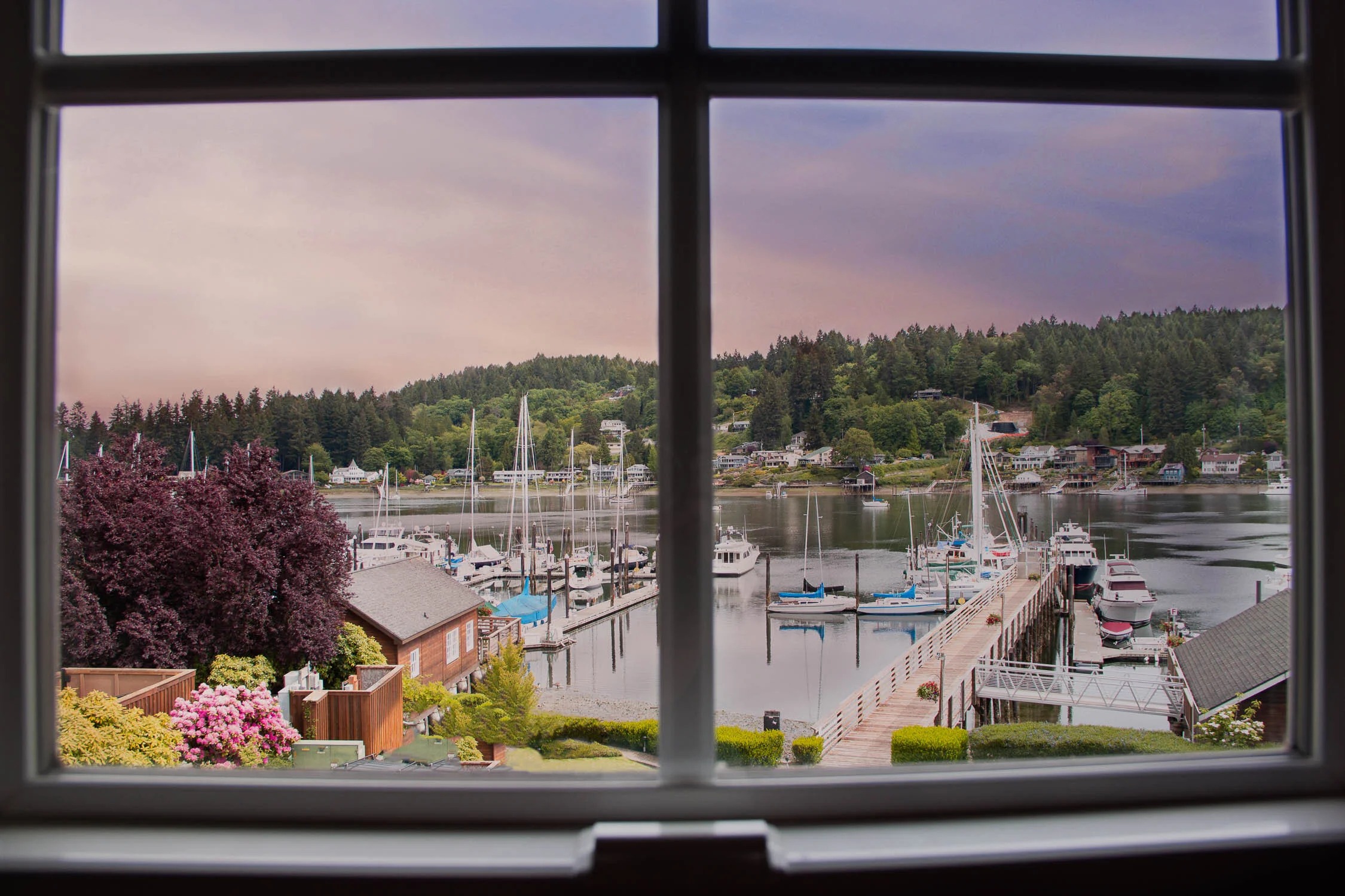 View of the Gig Harbor marina and forested shoreline through a window at Brix 25°